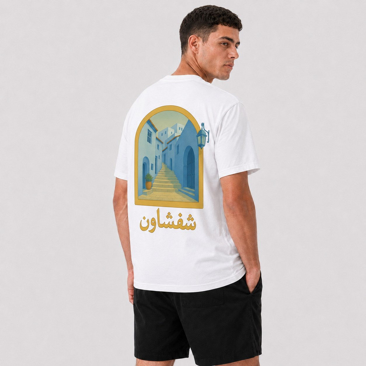 T-shirt Chefchaouen Safiri porté — vue de dos, ruelle bleue de la médina et calligraphie شفشاون