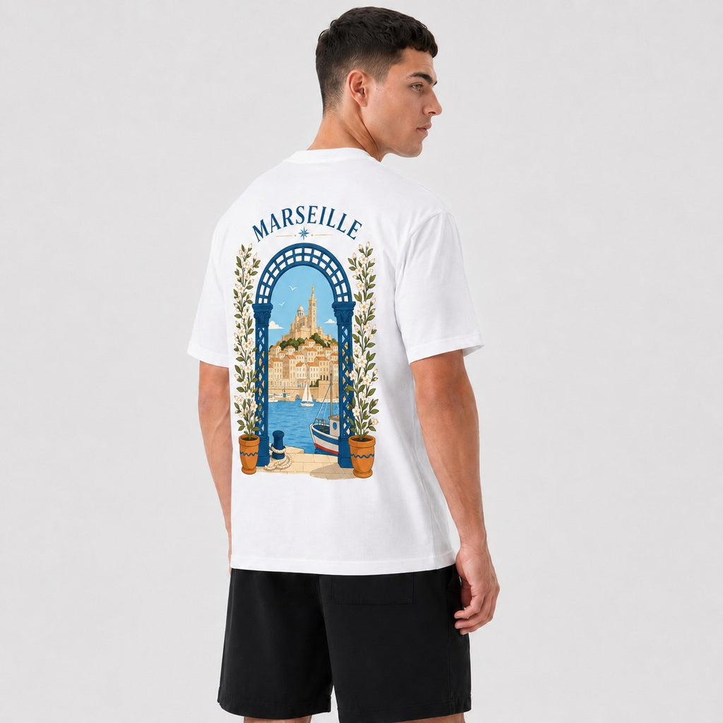 T-shirt Marseille Safiri porté — vue de dos, illustration du Vieux-Port et de la Bonne Mère sous une arche fleurie